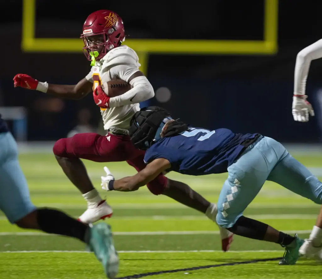 Long Beach Wilson’s Jemel Grigsby is tripped by Compton’s Edward...
