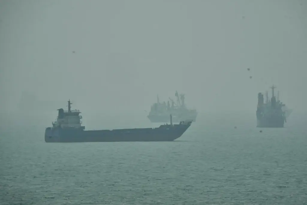 Commercial vessels anchored amid haze in the Strait of Hormuz...