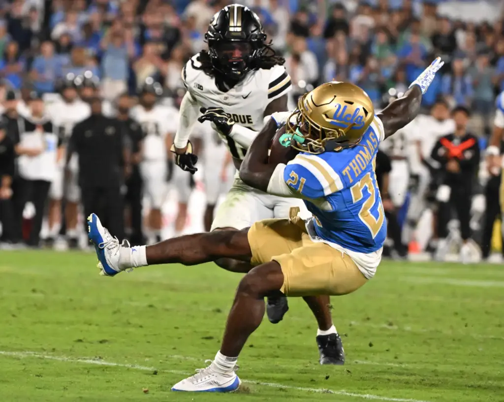 Running back Jaivian Thomas (21) of the UCLA Bruins runs...