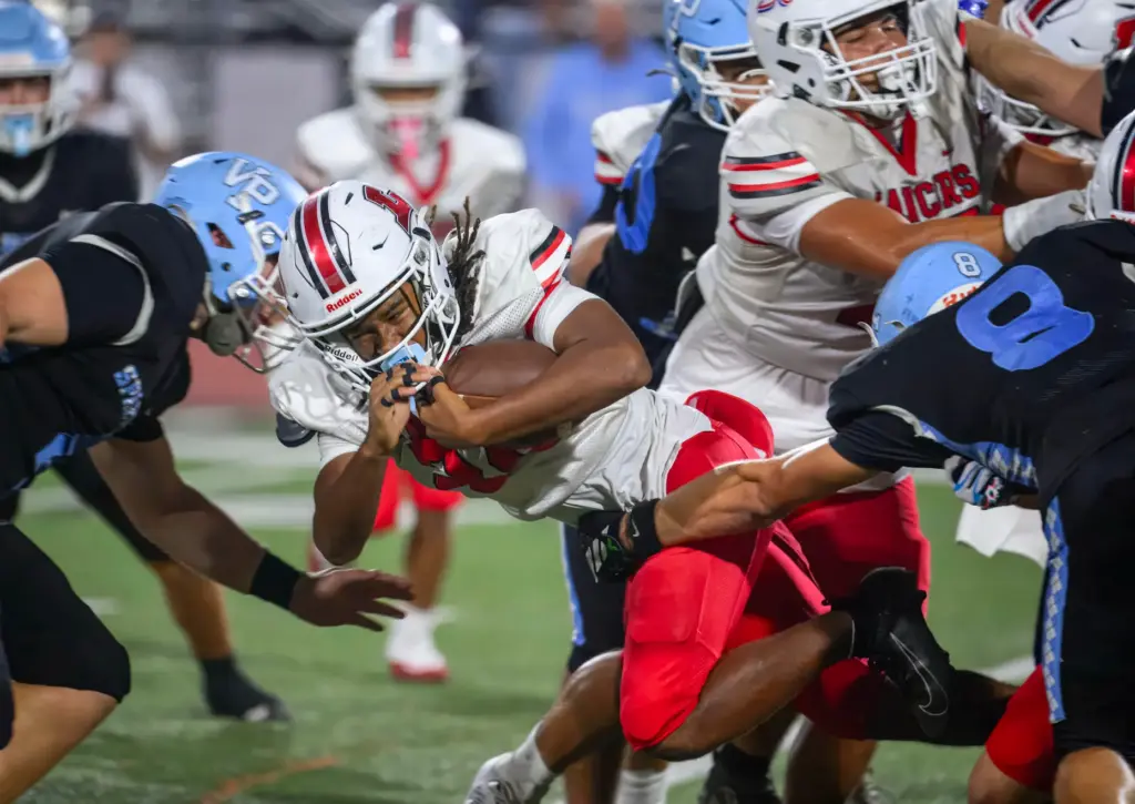Lakewood defensive back Jordan Montgomery, center, is stopped by Villa...