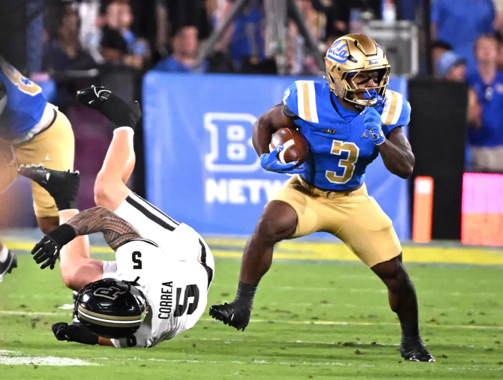 Running back Wayne Knight (3) of the UCLA Bruins runs...
