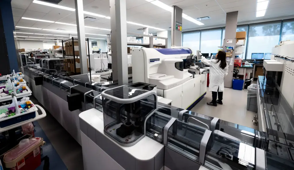A technician works with a sample analyzer at Hoag Irvine...