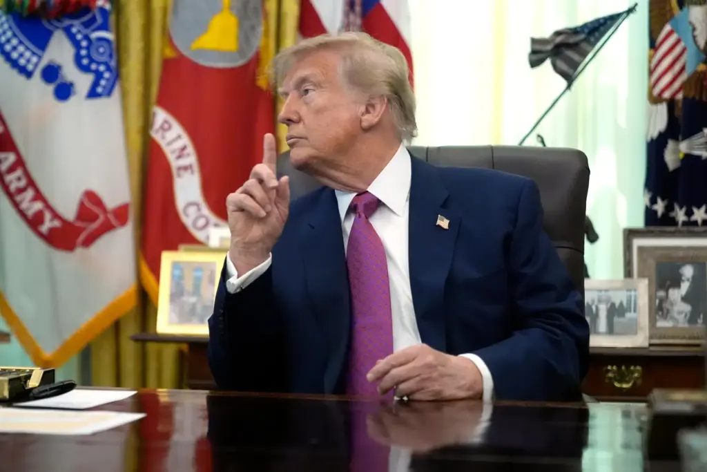 President Donald Trump gestures in the Oval Office of the...