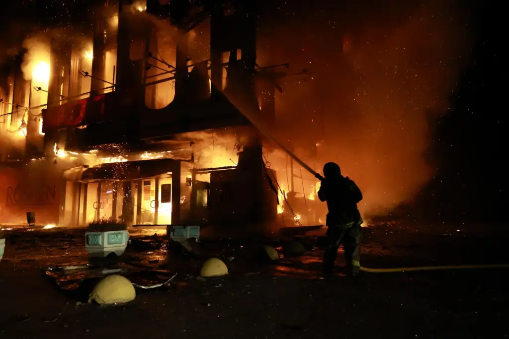 A rescue worker puts out a fire at the Intrade trade center after a Russian strike.