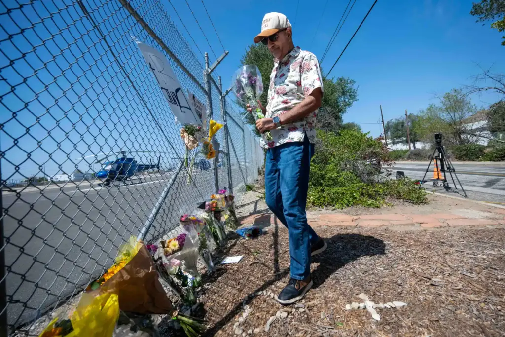 Pilot Frank Bagheri places flowers at a memorial for NBCLA...