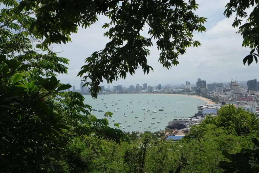 Boats float by Pattaya beach in Thailand.