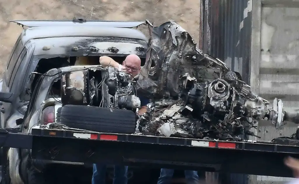 NTSB investigators remove of whatâs left of CH-4 helicopter Thursday,...