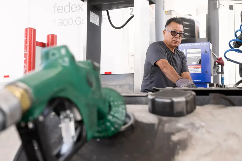 Truck driver Carlos Quintanilla refuels his diesel truck at SC...