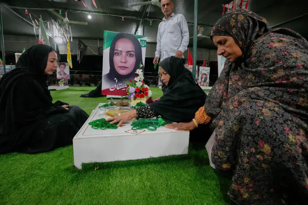 Fatemeh Barani, second from right, mourns at the grave of...