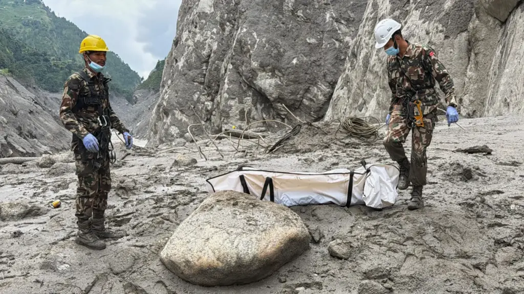 Nepal Army soldiers carry a body of a worker recovered from the site of a hydropower project.