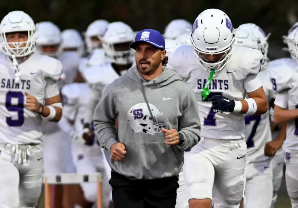 St. Anthony Saints head coach Jeff Magdaleno runs onto the...
