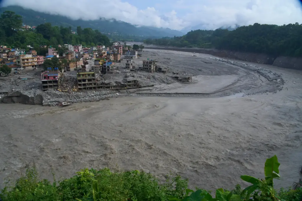 Houses damaged by flash floods are seen on the bank...
