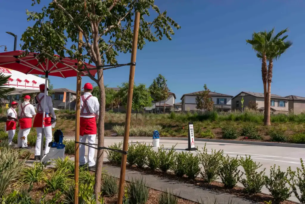 In-N-Out Burger employees stand at the ready beside the drive-thru...