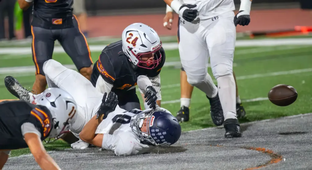 Trabuco Hills wide receiver Beckham Nolan, bottom, fumbles the ball...