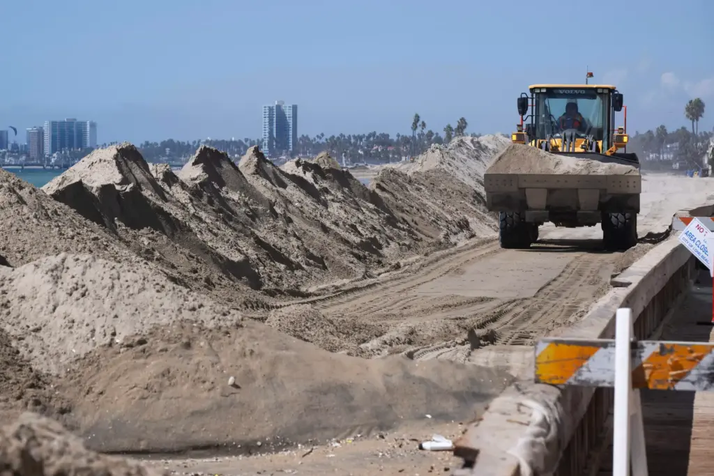 Crews work to reinforce vulnerable portions of the Long Beach...