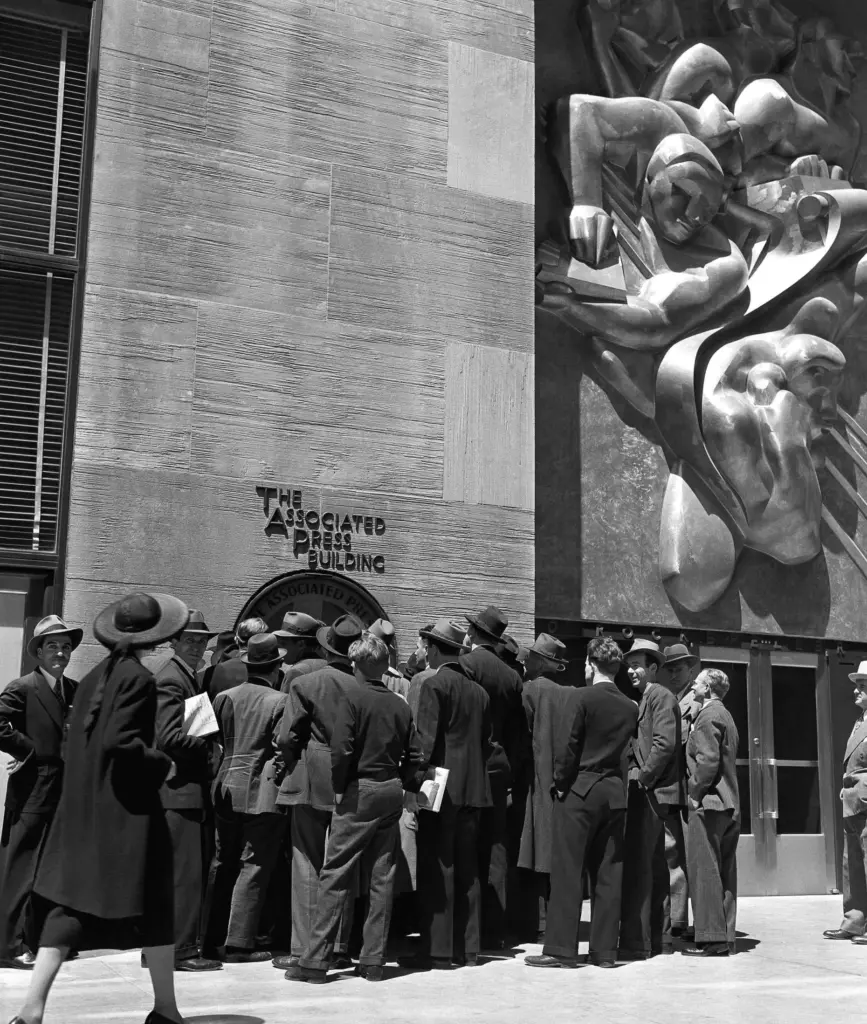 People surround the teletype machine at The Associated Press Building on Rockefeller Plaza.