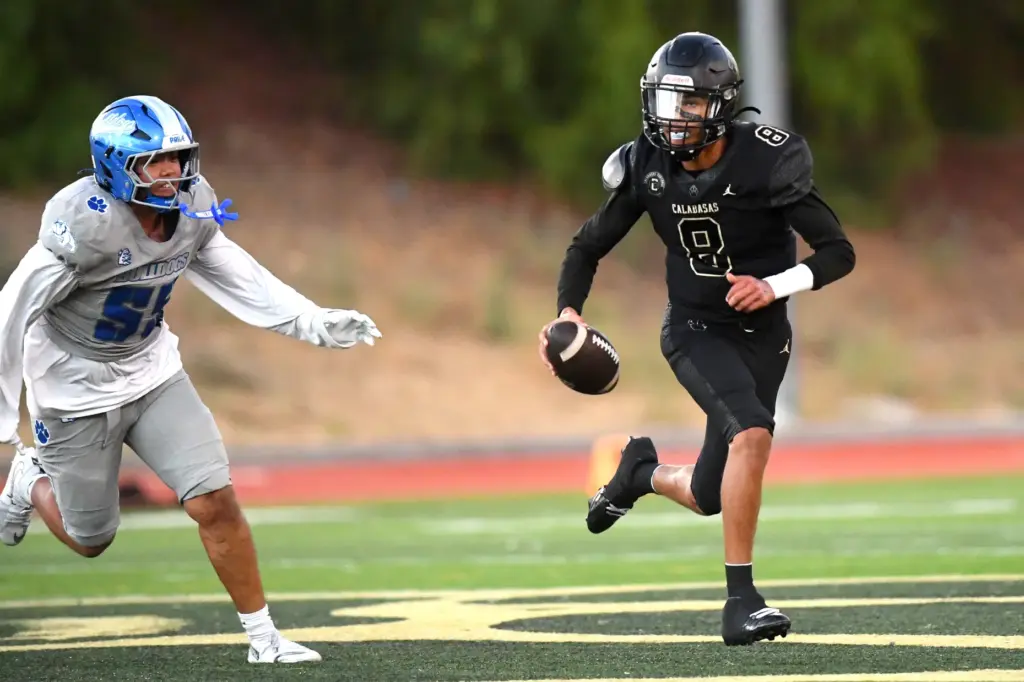 Calabasas quarterback Dominik Hardy scrambles to avoid being sacked by...