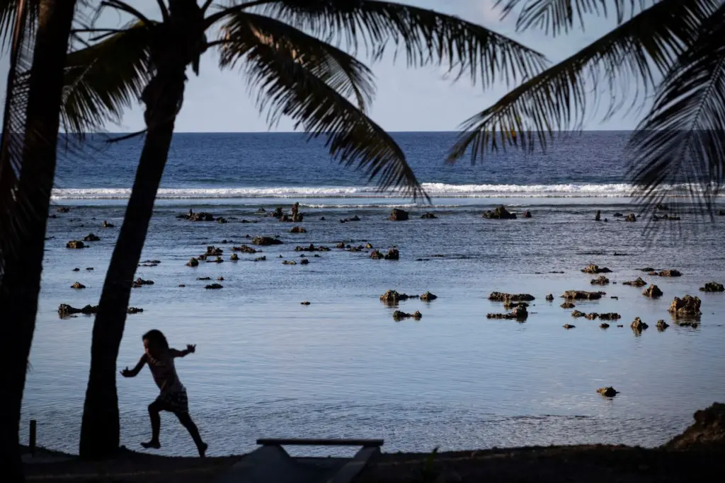 FILE- A child plays near the beach in Nauru during...