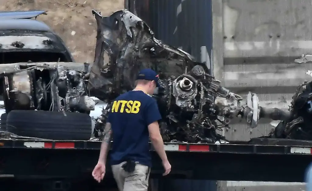 NTSB investigators remove of whatâs left of CH-4 helicopter Thursday,...