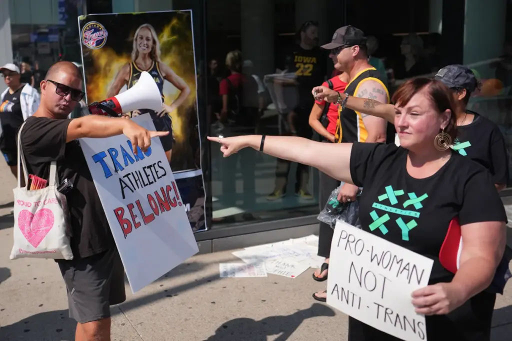 FILE – People hold signs and point after comments on...