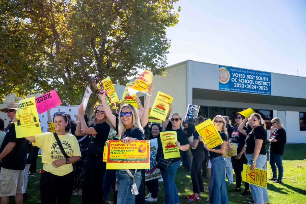 Members and supporters of the Saddleback Valley Educators Association raise...