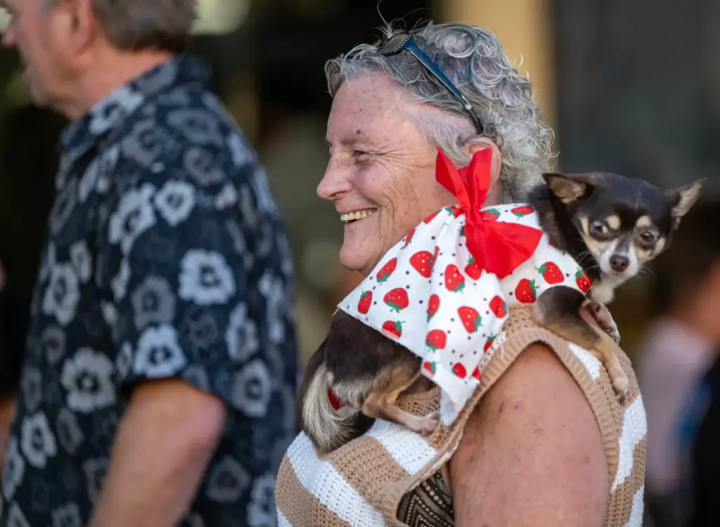 Kathy Bruner of Orange carries her dog, Topaz, on her...