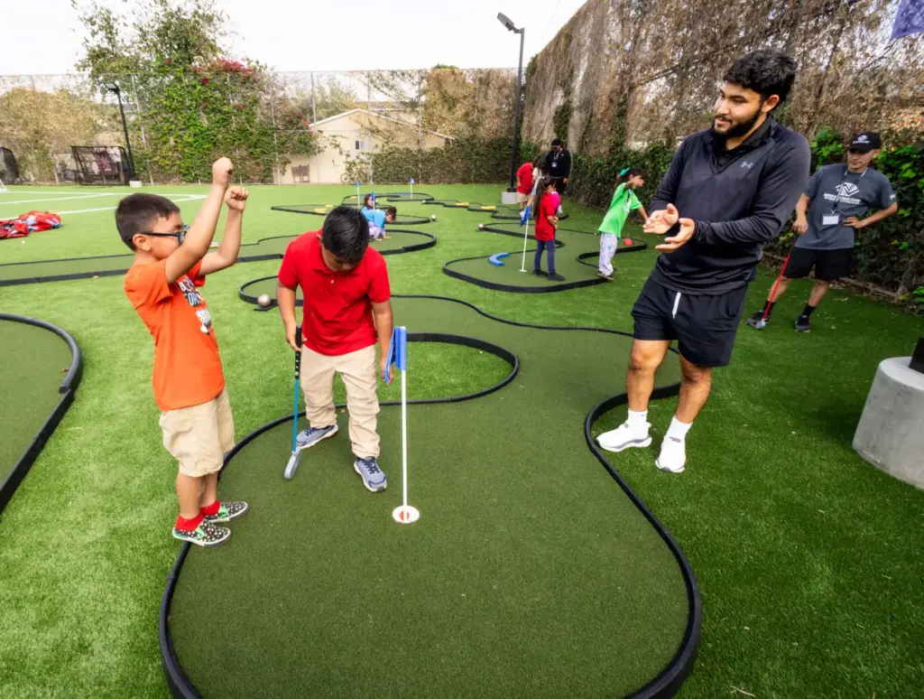 Kevin Cifuentes, 7, celebrates a successful golf putt by his...