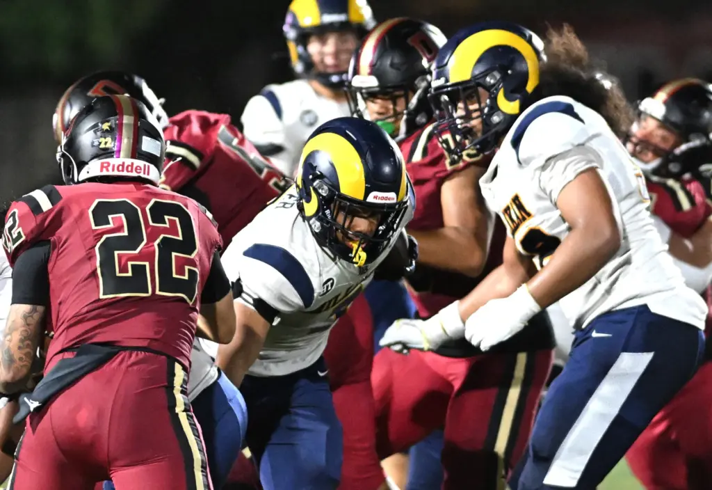 Millikan’s Ryan Carter (7) runs the ball for yards in...
