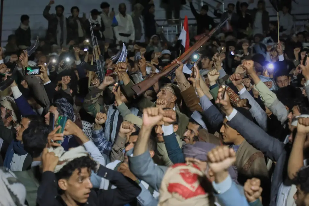 Supporters of Yemen's Houthi rebels raise rifles and their fists during a rally.