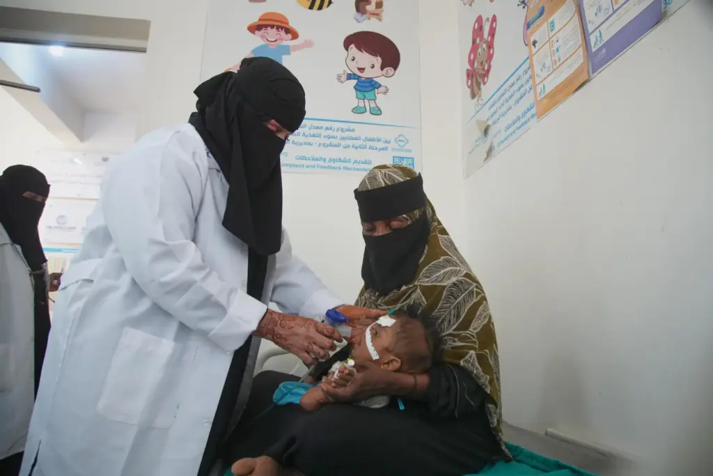 A health worker treats a child showing symptoms of malnutrition...