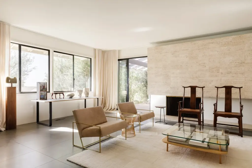 An original travertine fireplace wall anchors the living room. (Photo...