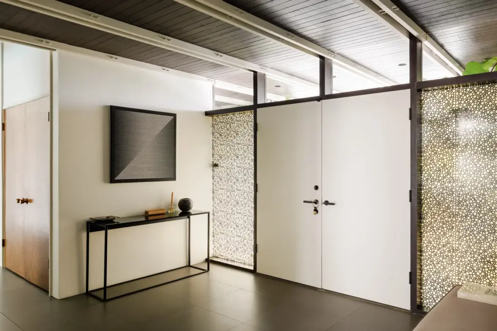 Double-entry doors flanked by translucent bubble-glass sidelights open into the...