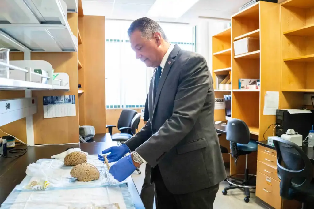 Sen. Alex Padilla holds a spinal stem while touring the...