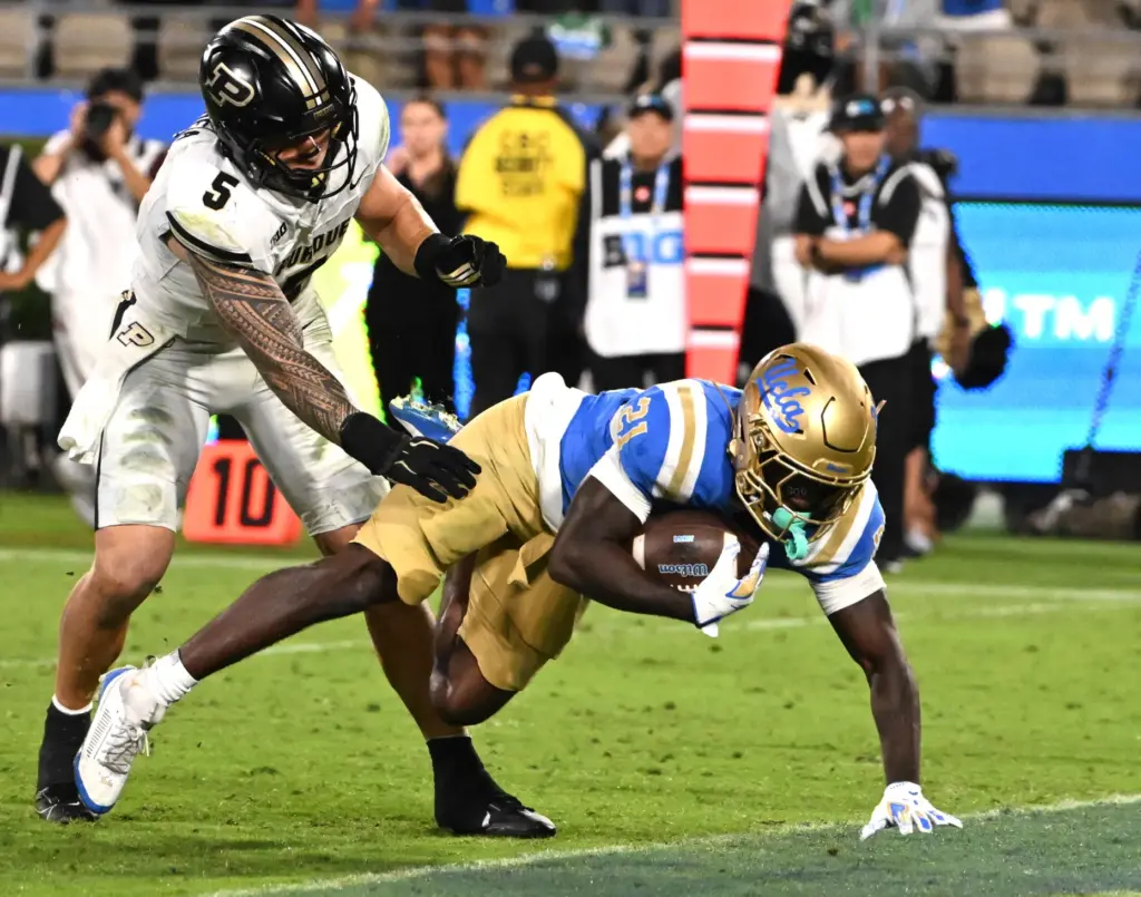 Running back Jaivian Thomas (21) of the UCLA Bruins runs...