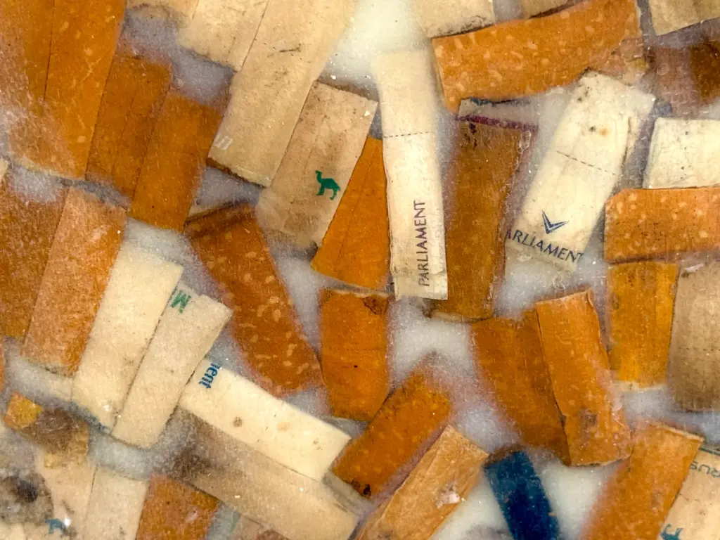 Detail of a surfboard made with cigarette butts collected from...