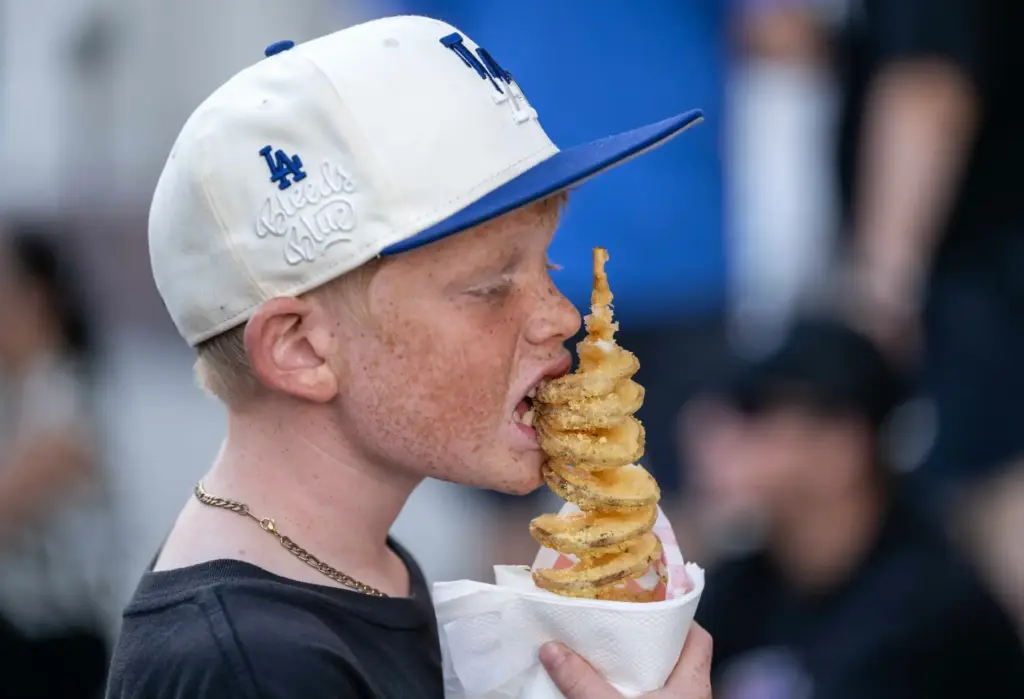 Benjamin Minegar, 12, of Orange takes a bite of his...