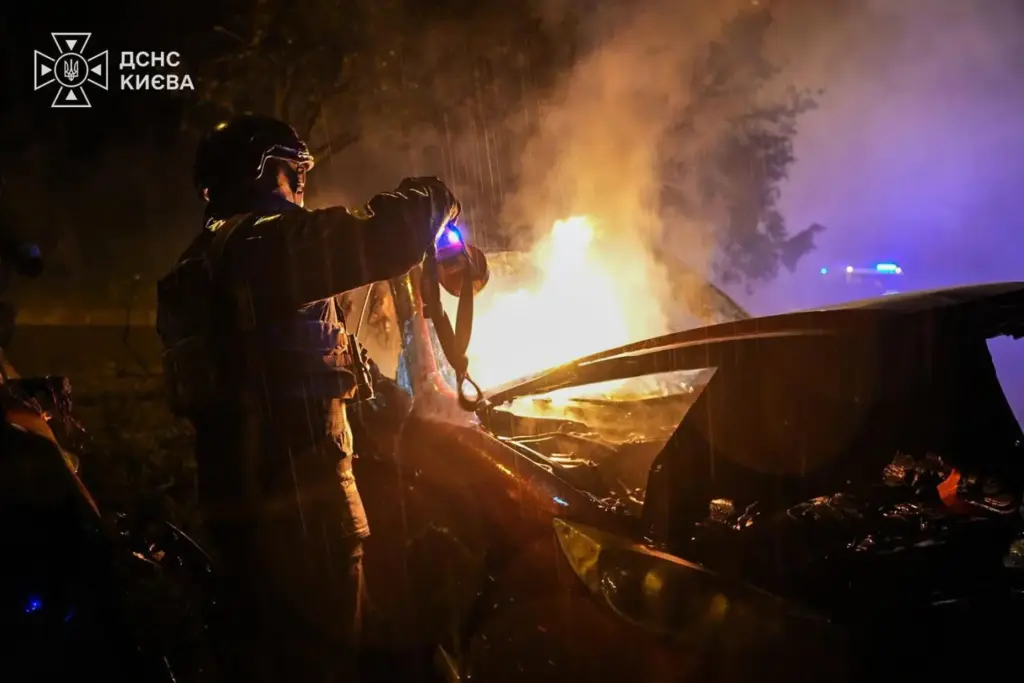 A rescue worker checks a car destroyed following a Russian strike on Kyiv.