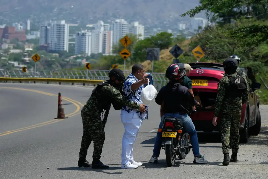 A soldier searches a motorist in Santa Marta, Colombia, Wednesday,...