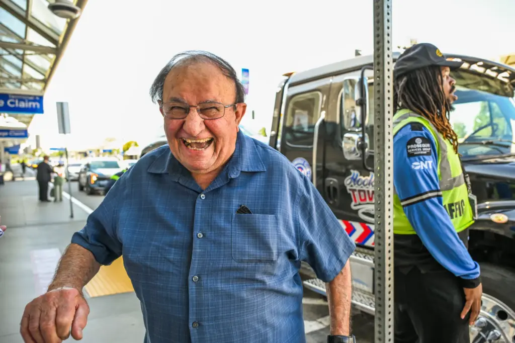 Fred Saca laughs as his car is towed away at...