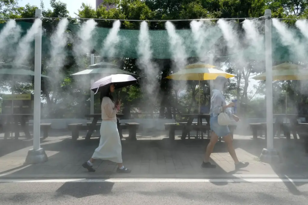 Visitors pass by the cooling fog device at Gwangmyeong Cave.