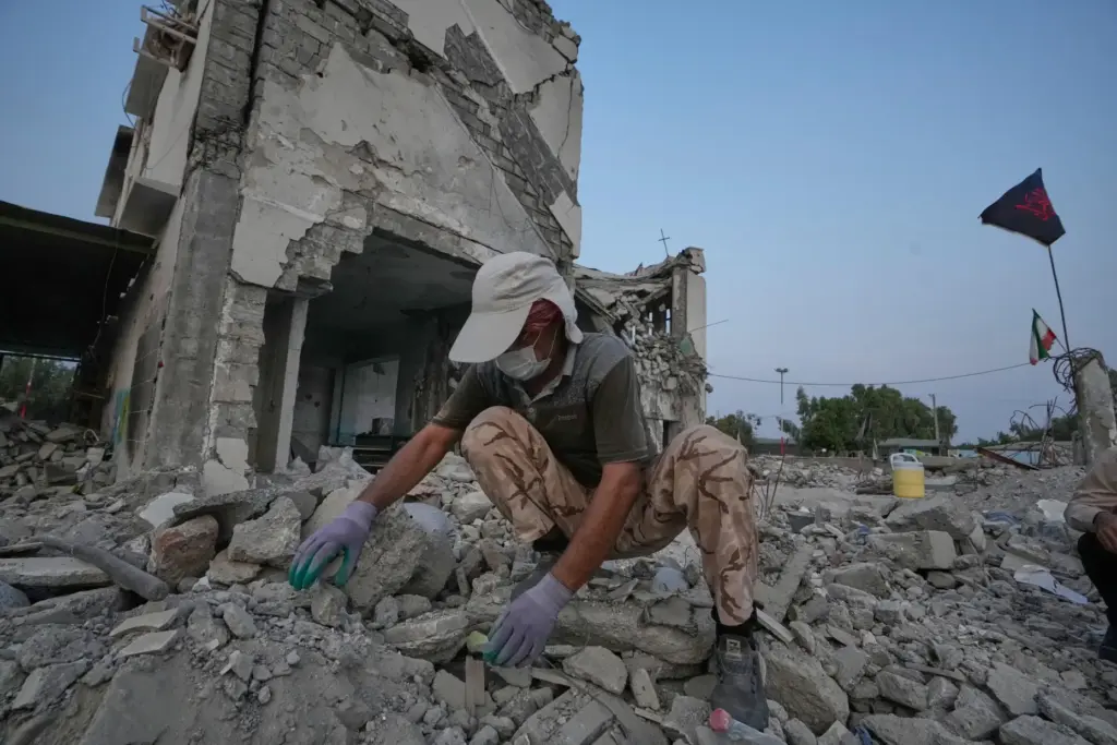 A volunteer searches through the rubble of Shajareh Tayyebeh school,...