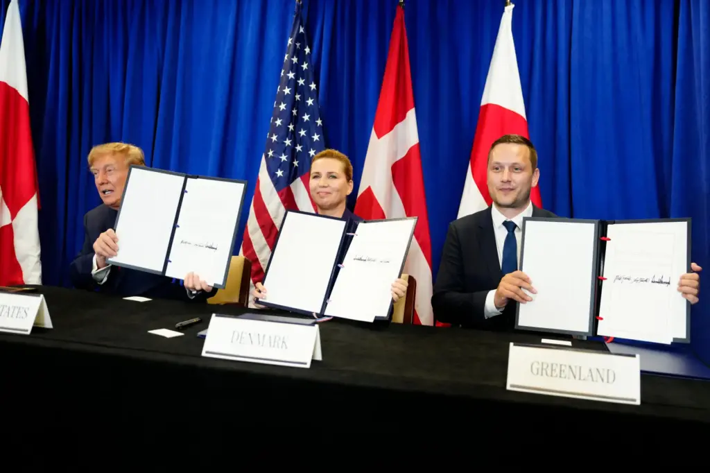 President Donald Trump signs a security agreement with Denmark's Prime Minister Mette Frederiksen and Greenland's Prime Minister Jens-Frederik Nielsen.