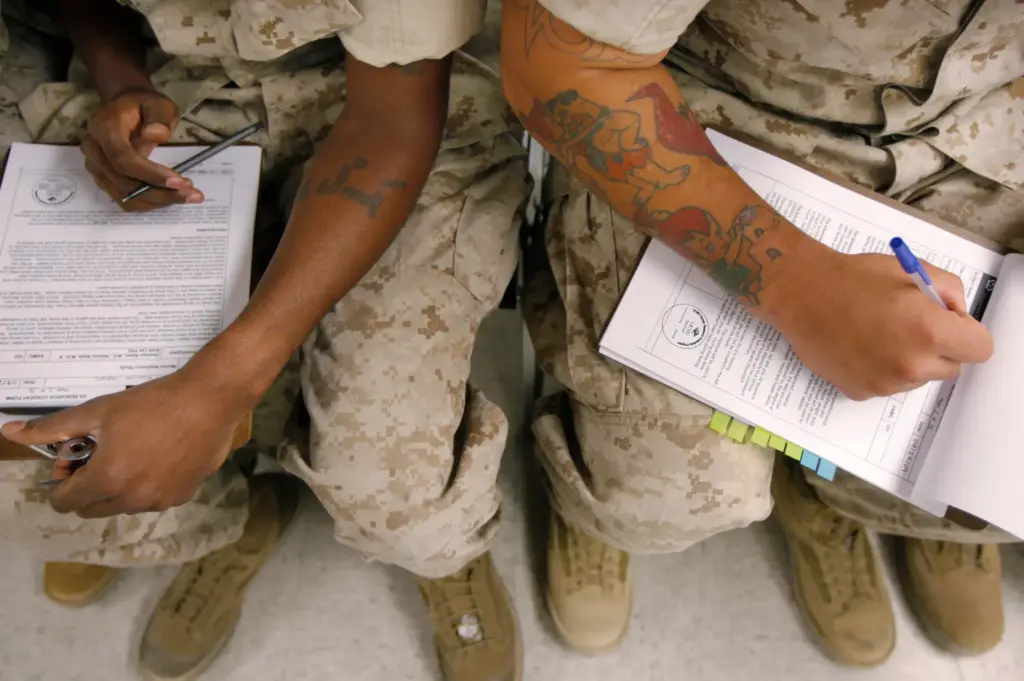 FILE – U.S. Marines fill out research consent forms before...