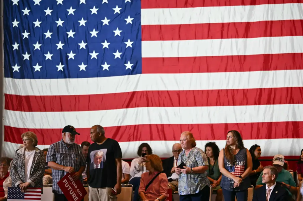 Attendees wait for Vice President JD Vance to arrive at a rally.