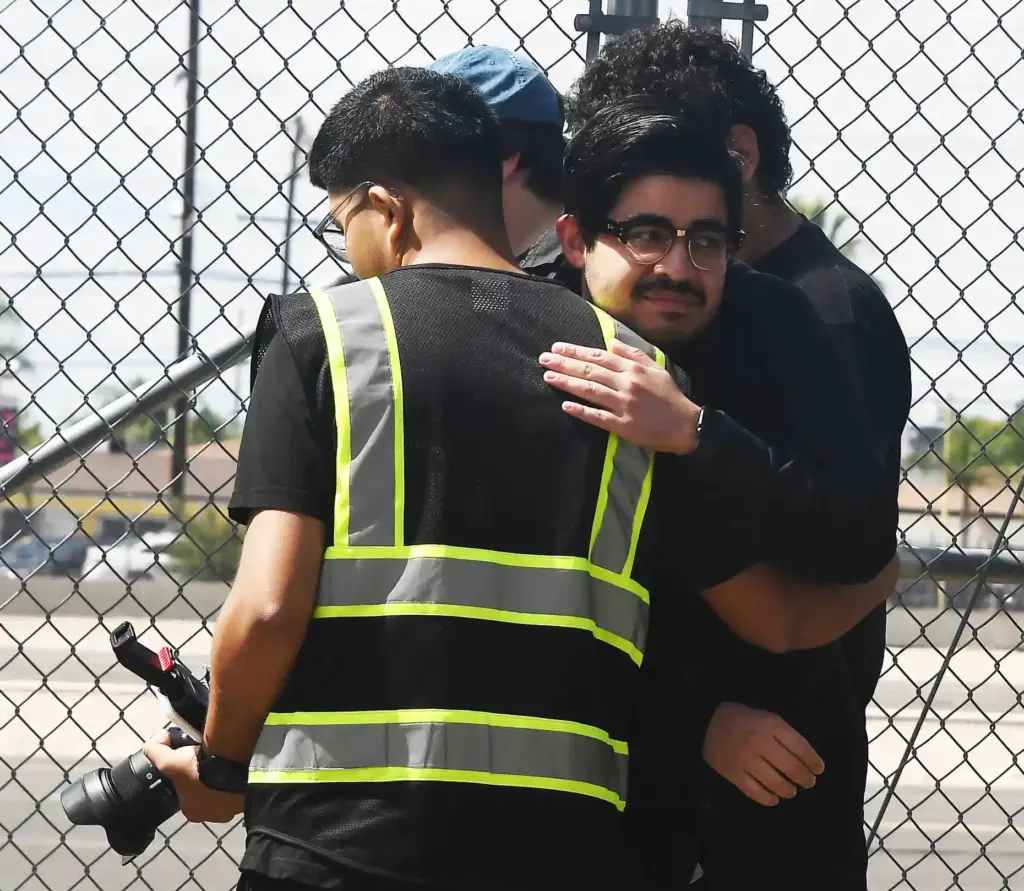 Friends comfort each other as they pay respects to CH-4...