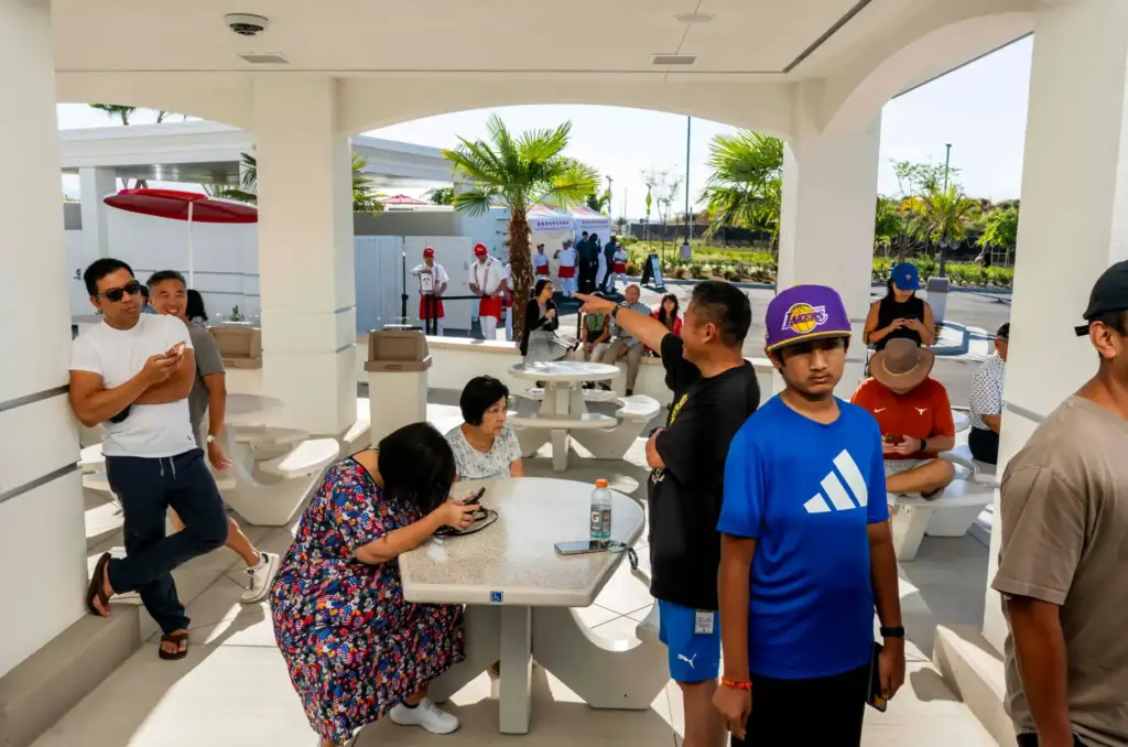 Patrons wait outside the side doors of In-N-Out Burger before...