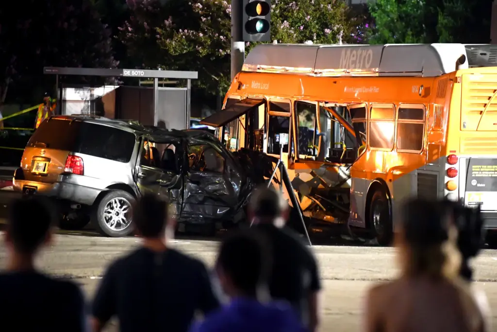 Onlookers survey the scene of a collision between a Metro...