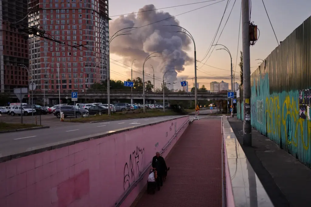 A man walks along an underpass as smoke rises following...