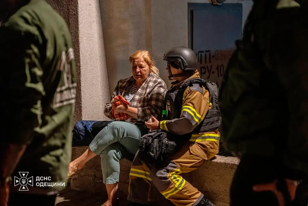 A firefighter comforts a woman after her home was damaged in a Russian air attack.