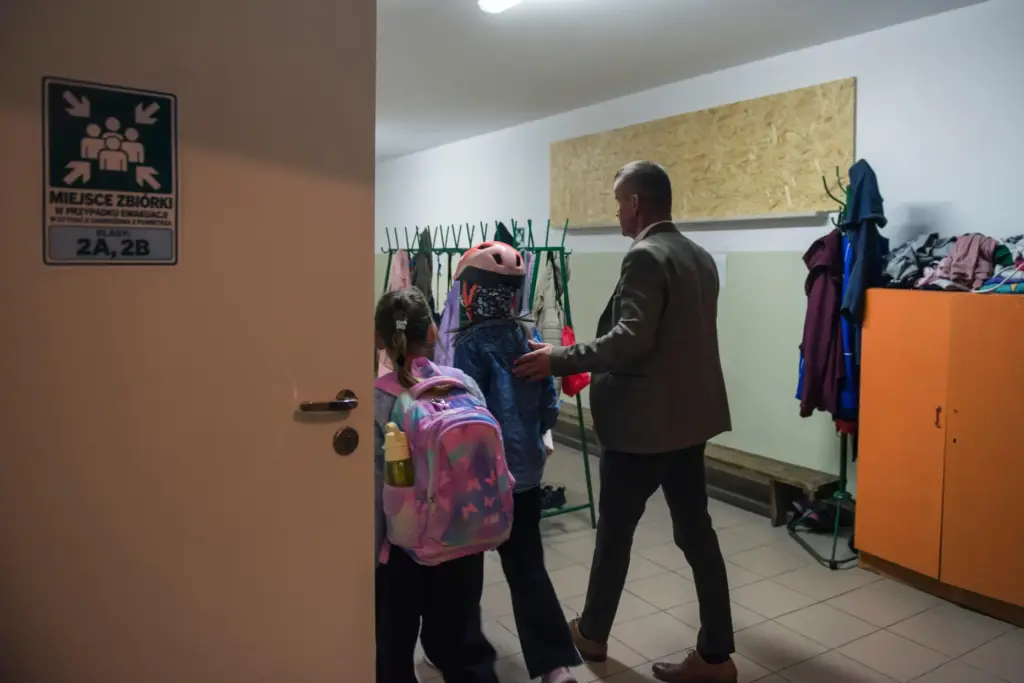 Jarosław Wojcik, the school principal guides children into a school...